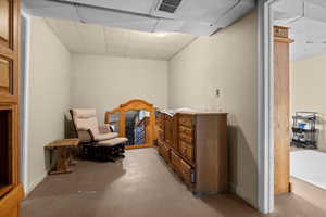 living space featuring concrete floors and a paneled ceiling