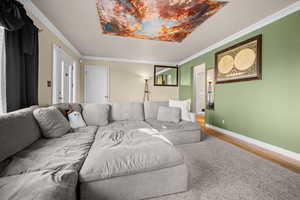 Living area with crown molding and wood finished floors