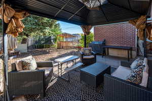 View of patio with a trampoline, outdoor lounge area, and grilling area