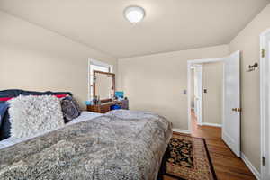 Bedroom featuring wood finished floors and baseboards