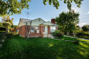 Bungalow-style home with brick siding and a chimney