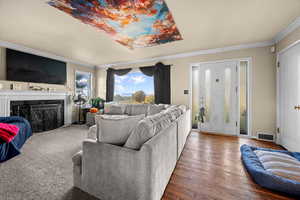 Living area with a fireplace, crown molding, and wood finished floors