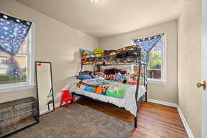 Bedroom featuring wood finished floors and baseboards