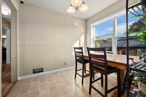 Dining room featuring wainscoting and a chandelier