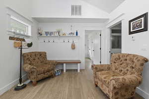 Living area featuring wood finished floors and lofted ceiling