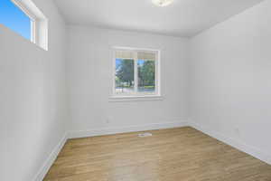 Empty room with light wood finished floors and baseboards