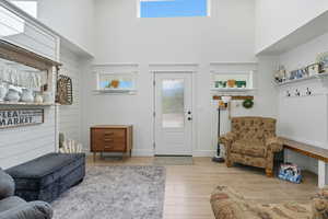 Living room featuring light wood-style flooring and a high ceiling