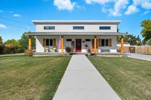 View of front facade featuring a porch, board and batten siding, and a metal roof