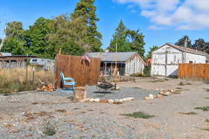 View of yard featuring an outdoor structure and a fire pit