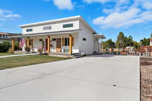 Modern farmhouse with a porch, a front yard, and board and batten siding