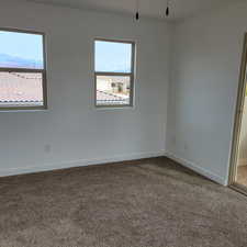 Carpeted spare room featuring baseboards