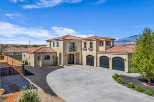 Mediterranean / spanish house with stucco siding, a tiled roof, concrete driveway, and a garage
