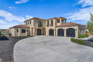 Mediterranean / spanish-style house featuring concrete driveway, stucco siding, a tiled roof, and a garage