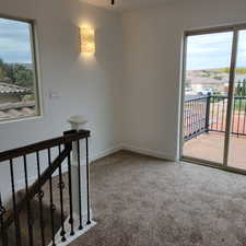 Spare room featuring light carpet and baseboards