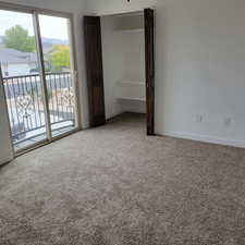 Unfurnished bedroom featuring light colored carpet and access to exterior
