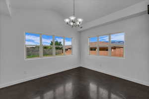 Empty room with a chandelier and lofted ceiling