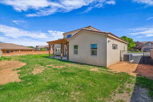 Rear view of house with a patio area, a pergola, stucco siding, and a fenced backyard