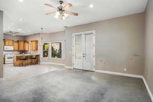 Unfurnished living room with light colored carpet, french doors, ceiling fan, recessed lighting, and light tile patterned floors