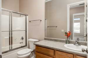 Full bathroom with shower / bath combination with glass door and vanity