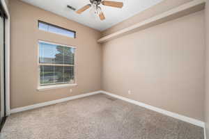 Carpeted spare room with baseboards and a ceiling fan
