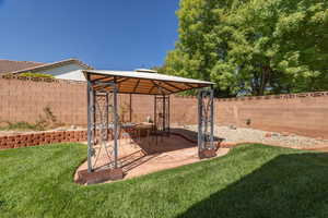 Fenced backyard featuring a gazebo and a patio