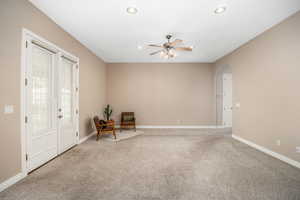 Unfurnished room with arched walkways, carpet flooring, recessed lighting, and ceiling fan