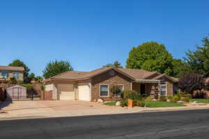 Ranch-style home featuring stone siding, a gate, concrete driveway, stucco siding, and a garage