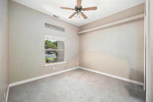 Empty room with carpet and ceiling fan