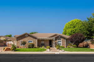 Single story home featuring stone siding, a gate, covered porch, stucco siding, and a tiled roof