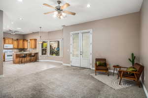 Living room with french doors, light carpet, ceiling fan, recessed lighting, and light tile patterned flooring