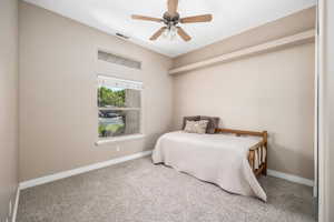 Carpeted bedroom featuring baseboards and ceiling fan
