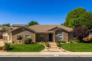 Ranch-style house featuring stone siding, a porch, a tile roof, and stucco siding