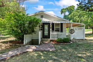 View of front facade featuring a front yard and covered porch