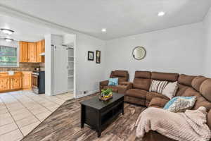 Living area with light tile patterned floors, crown molding, and recessed lighting