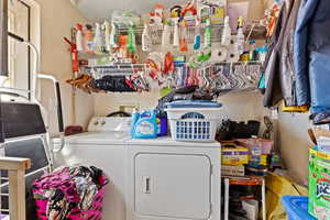 Washroom with washer and dryer and a textured ceiling