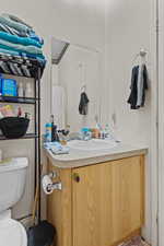 Full bath featuring a textured wall, vanity, and curtained shower