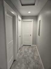 Hallway with recessed lighting and electric panel