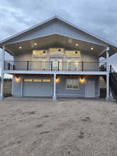 View of front facade with a wooden deck, driveway, a garage, and stairs