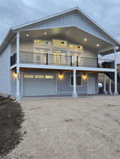 View of front of house with board and batten siding and dirt driveway