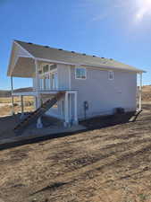 Back of house with stairs and roof with shingles