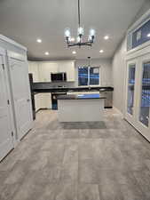 Kitchen with recessed lighting, stainless steel appliances, pendant lighting, white cabinets, and a chandelier
