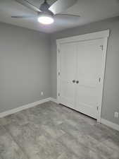 Unfurnished bedroom featuring ceiling fan and a closet