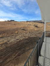 View of yard with a balcony and a view of rural / pastoral area