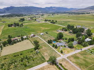 Aerial view of property and surrounding area with rural landscape, a mountain backdrop, and extensive farmland