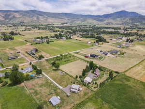 Aerial view of property and surrounding area with a mountainous background and rural landscape
