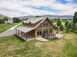 Back of house with a yard, board and batten siding, a deck with mountain view, and a metal roof