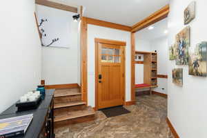 Foyer entrance featuring dark stone finish flooring, stairs, and recessed lighting