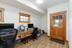 Home office with light wood-style floors and baseboards