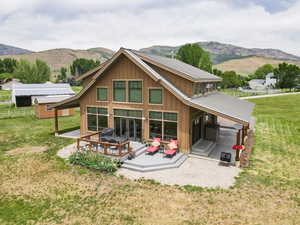 Rear view of property with board and batten siding and a deck with mountain view