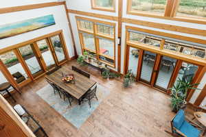 Dining area featuring french doors, hardwood / wood-style floors, and a towering ceiling